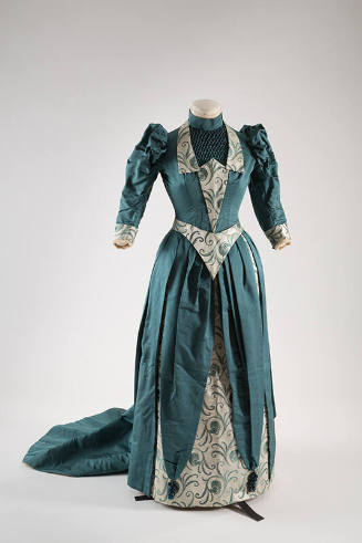Blue green two-piece floor length dress with puffed sleeves, white and blue green brocade trim …
