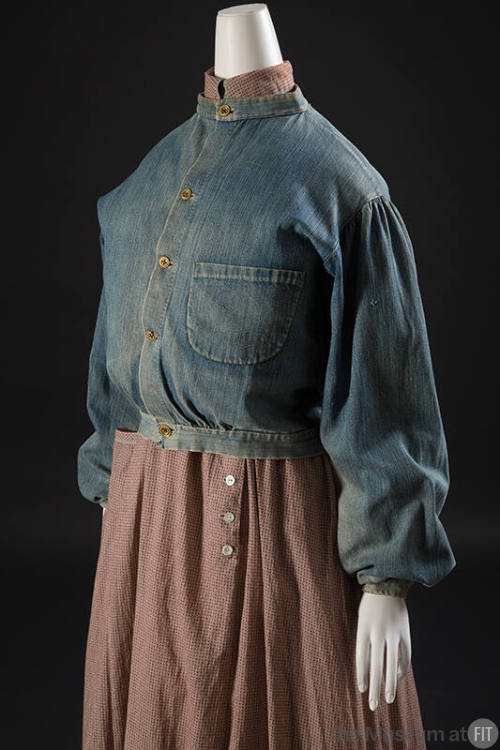 ¾ view of blue denim button front jacket with band collar, right patch pocket and loose sleeves…