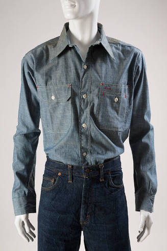 Blue denim long sleeve tailored shirt with button front, two buttoned patch pockets and red sti…