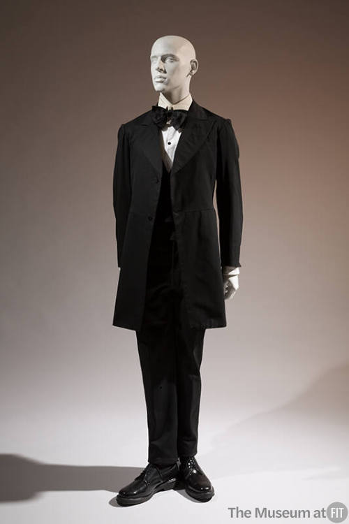 Black wool frock coat with wide lapels, black vest and pants, satin bow tie
