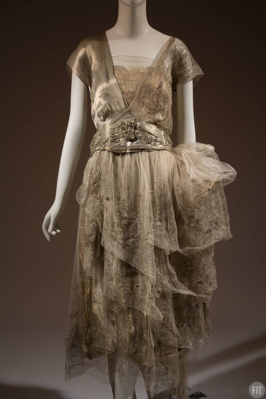 Silver lamé cap sleeve v-neck dress with embroidered net and chiffon camisole and layered skirt…