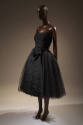 Black tulle strapless dress with full below-the-knee skirt with large black silk bow at waist