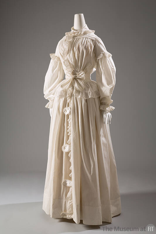 White cotton long sleeve gown with eyelet ruffles and trim, floor-length gathered skirt with bu…