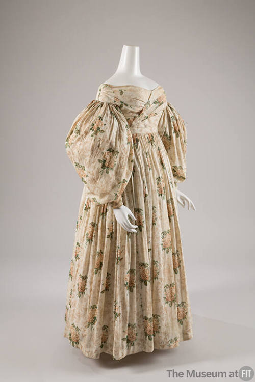 Off the shoulder, off-white day dress with floral print, long puffed sleeves, and long gathered…