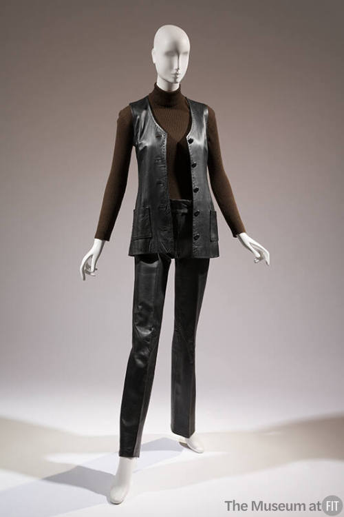 Black leather button front vest, brown turtleneck long sleeve top and black leather pants