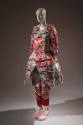¾ view of pink floral jacquard tunic ensemble showing cut outs at midriff, extending layered hi…