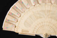 Detail view of white fan with painted rose buds
