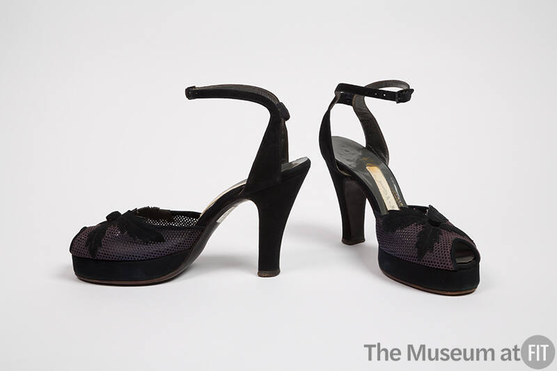 Pair of navy open toe ankle strap high heel sandals with bar across ankle and x-shaped leaf app…