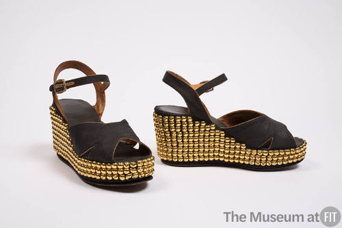 Pair of black platform sandals with crossing straps at vamp, ankle strpas gold-studded wedge he…