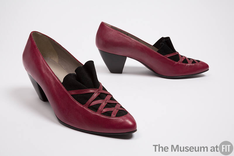 Pair of red pumps with ruffled black apron under latticework vamp and stacked tapered heel