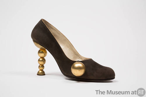 Brown evening pump with sculpted high heel of gold metal graduated balls, and pendant gold ball…
