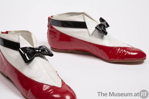 Pair of red patent leather ankle boots with white and black uppers to mimic a man’s tuxedo
