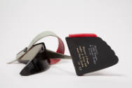 Bottom view of red, black and grey sandal showing gold embossed Charles Jourdan logo on sole