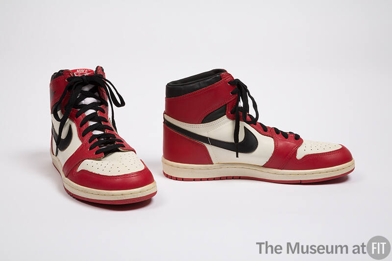 Pair of red, white, and black man’s high top sneakers with black Nike swoosh logo on the side