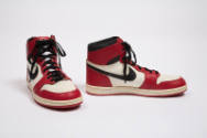 Pair of red, white, and black man’s high top sneakers with black Nike swoosh logo on the side