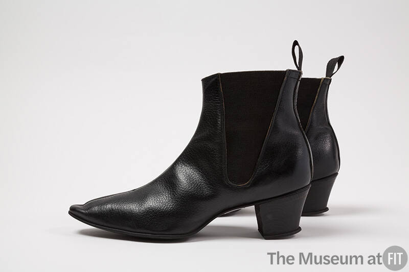 Pair of black ankle boots with pointed toe, elasticized triangular side panels and loop pull