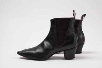 Pair of black ankle boots with pointed toe, elasticized triangular side panels and loop pull
