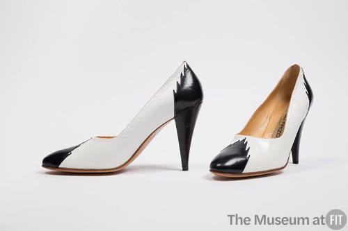 White pumps with black toe cap and high heel with flame edging 