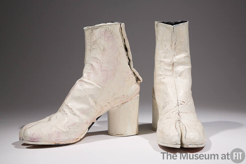 Pair of white painted ankle height boots with high cylindrical heel and split toe
