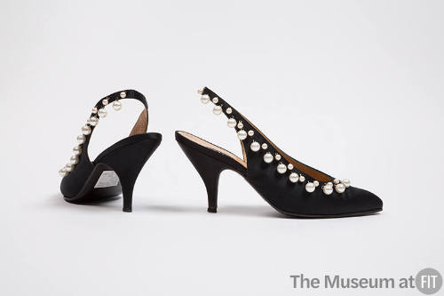 Pair of black slingback shoes with white pearls along topline and high heel