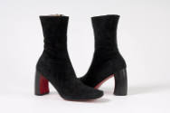 Pair of black ankle boots with curved heel and red sole