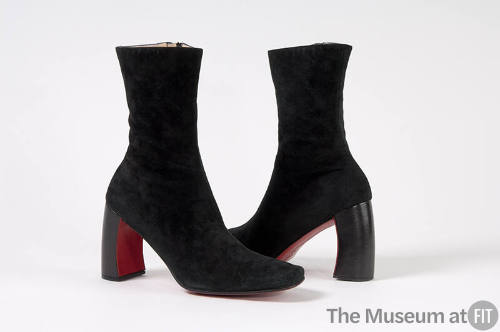 Pair of black ankle boots with curved heel and red sole