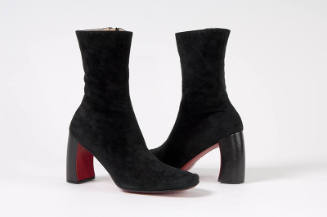 Pair of black ankle boots with curved heel and red sole
