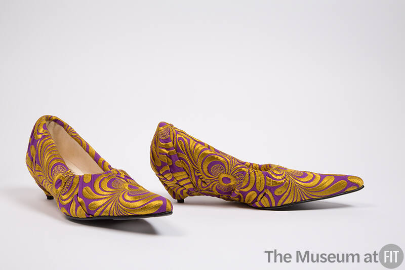 Pair of purple pumps with abstract gold brocade, fabric draped over heel and elongated poined t…
