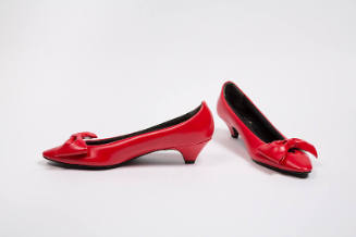 Pair of padded red pumps with large self bow at vamp, medium heel and pointed toe