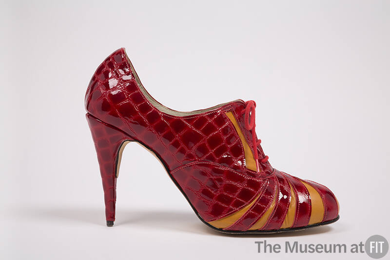 Side view of red patent leather alligator embossed print high heel lace front shoe with orange …