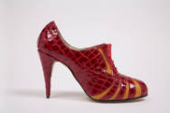 Side view of red patent leather alligator embossed print high heel lace front shoe with orange …