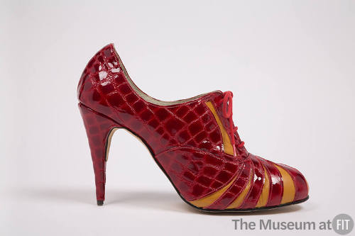 Side view of red patent leather alligator embossed print high heel lace front shoe with orange …