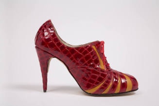 Side view of red patent leather alligator embossed print high heel lace front shoe with orange …