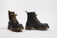Black lace-up work boots with yellow stitching and  thick brown soles 