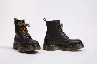 Black lace-up work boots with yellow stitching and  thick brown soles 