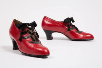 Red ghillies with black scalloped trim, loops and heel; ribbon ties