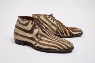 Pair of man’s brown and white zebra print shoes with triple eyelet lace closure