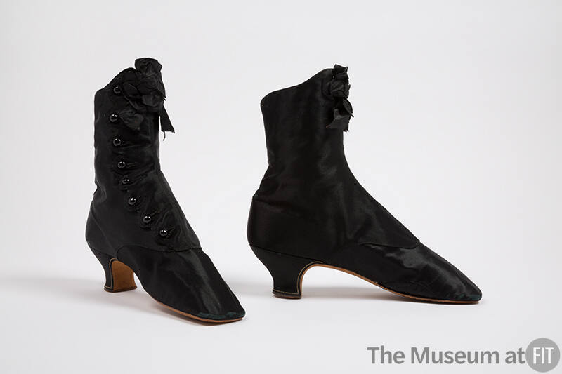 Pair of black above the ankle boots with button front closure, black rosette bow at front top a…