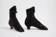 Pair of black above the ankle boots with button front closure, black rosette bow at front top a…