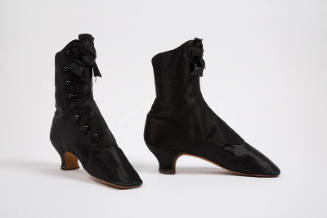 Pair of black above the ankle boots with button front closure, black rosette bow at front top a…