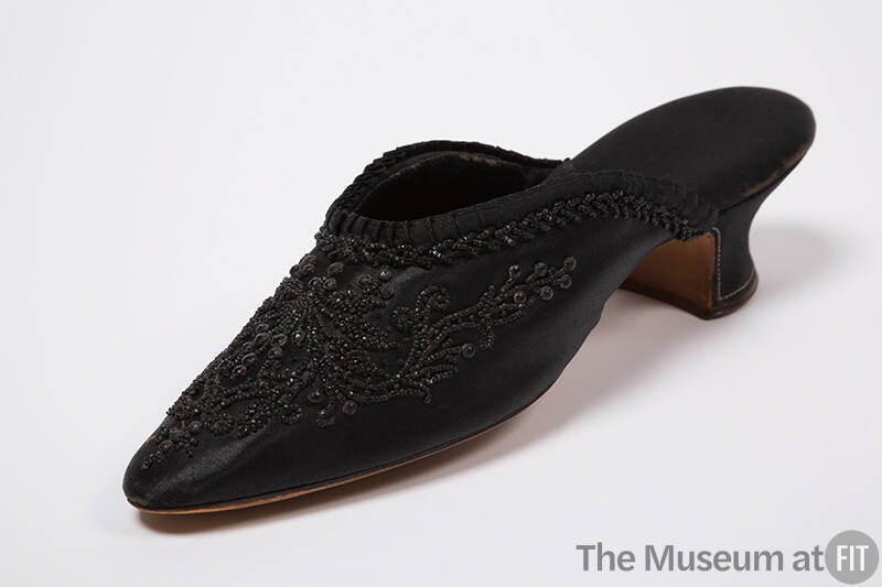 Black mule slipper with jet beading in a scrolling floral pattern, rounded pointed toe and cove…