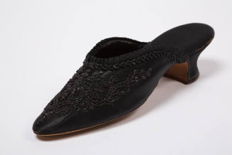 Black mule slipper with jet beading in a scrolling floral pattern, rounded pointed toe and cove…