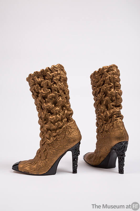Bronze metallic mid calf high heel boots with overall puckered quilt stitch and black toe cap, …