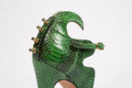 Green snakeskin high heel with swirling top edge; gold metal protruding studs at center back