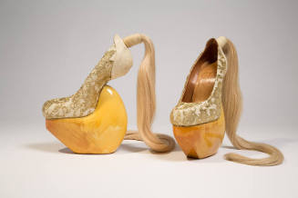 gold metallic lace over beige heel-less shoes with high wood platform and blond hair ponytail a…