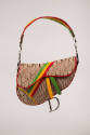Tan asymmetrically shaped handbag with brown Dior monogram print, green, yellow and red accent …
