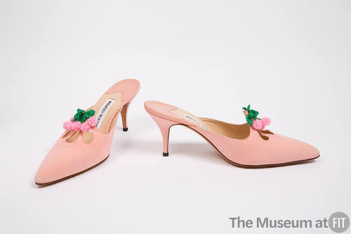 Pair of pink high heel mules with pointed toe and eyelet cutouts topped with beaded pink and gr…