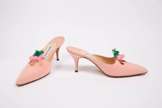 Pair of pink high heel mules with pointed toe and eyelet cutouts topped with beaded pink and gr…