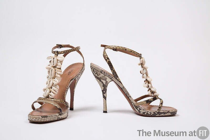 Pair of snakeskin stiletto heel sandals with ankle strap and cowrie shells on T-strap