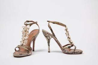 Pair of snakeskin stiletto heel sandals with ankle strap and cowrie shells on T-strap